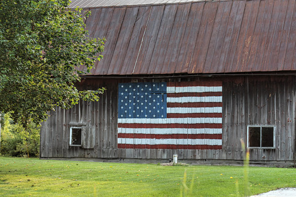 old barn with a painting of the American flag on the side in nostalgic photography