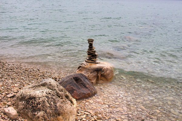 flat rocks balanced on large boulders in lake michign