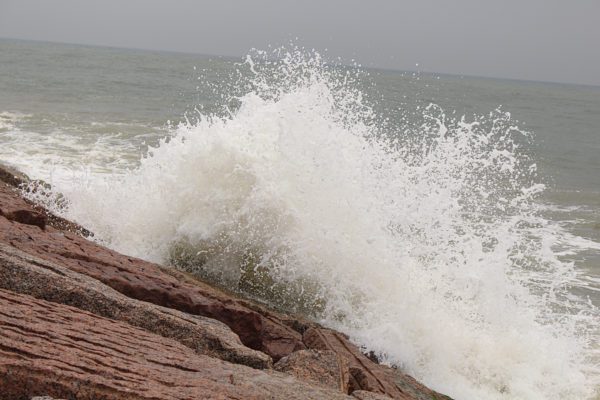 big waves splash and spray over jetty mustang island