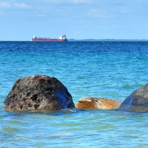 ship sales on lake michigan with large boulders on shoreline