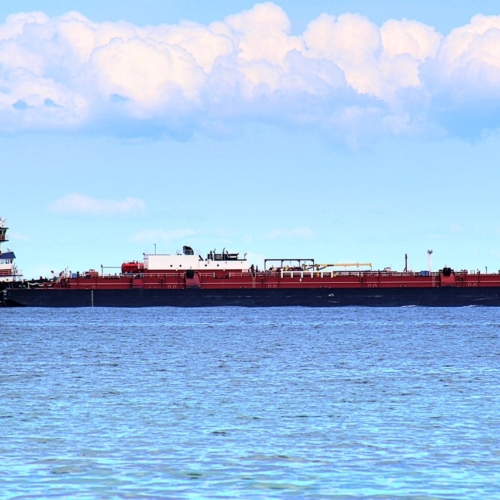 large iron or copper ore ship sales across lake michigan with clouds overhead