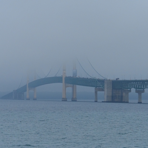 large suspension bridge over lake huron disappears into the fog