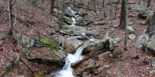 waterfall running off mountain over large rocks