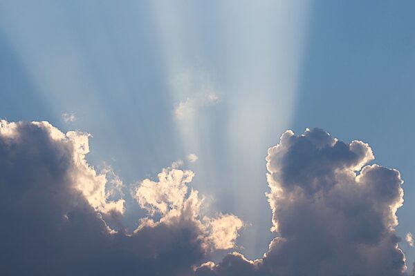 huge sunbeam streams down behind clouds